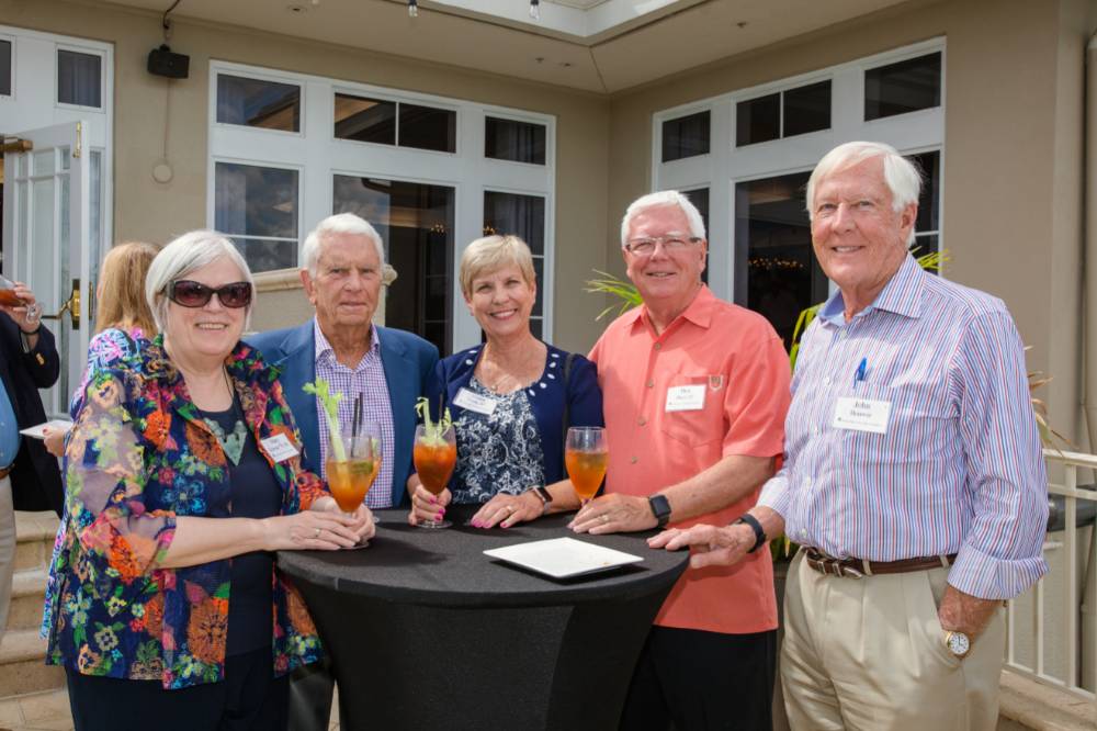 Group of guests standing outside at a table at Naples 2019
